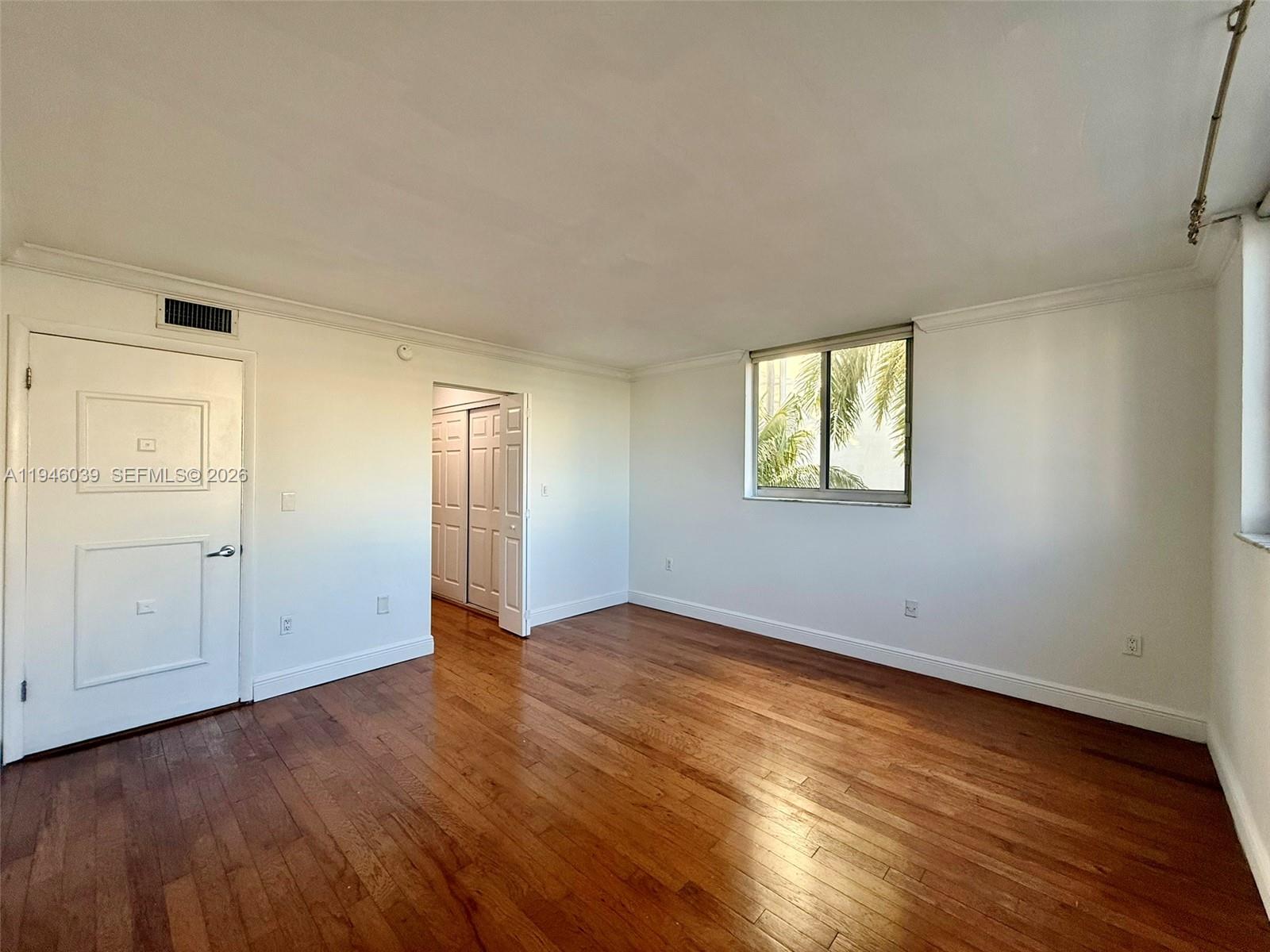 1605 Bay Road, Unit 407 Miami Beach, FL 33139 - Photo 25 of 31 an empty room with wooden floor and windows