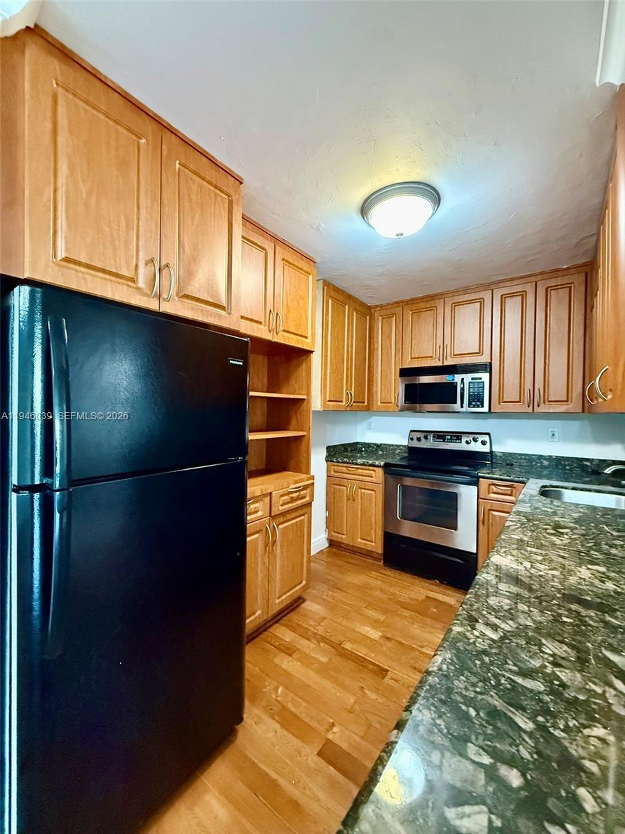 1605 Bay Road, Unit 407 Miami Beach, FL 33139 - Photo 10 of 31 a kitchen with stainless steel appliances a refrigerator and a stove top oven