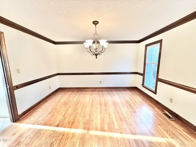 a living room with a large window and chandelier