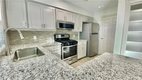 a kitchen with stainless steel appliances granite countertop a stove a sink and a microwave