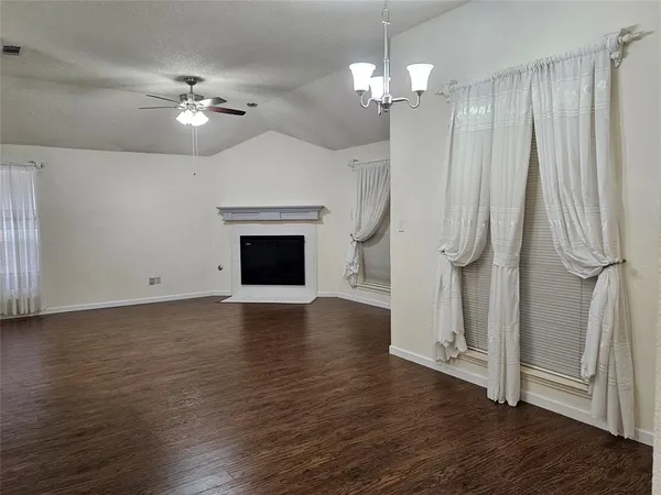 a view of a livingroom with a fireplace wooden floor and chandelier