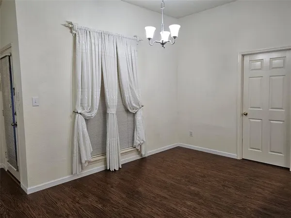 an empty room with wooden floor and window
