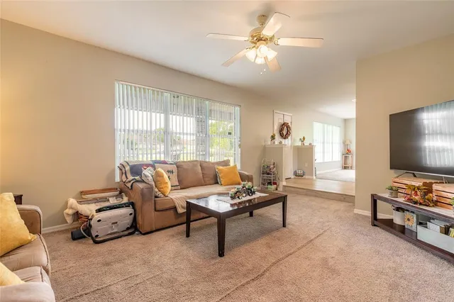 a large open kitchen with stainless steel appliances kitchen island granite countertop a table chairs in it and wooden floors