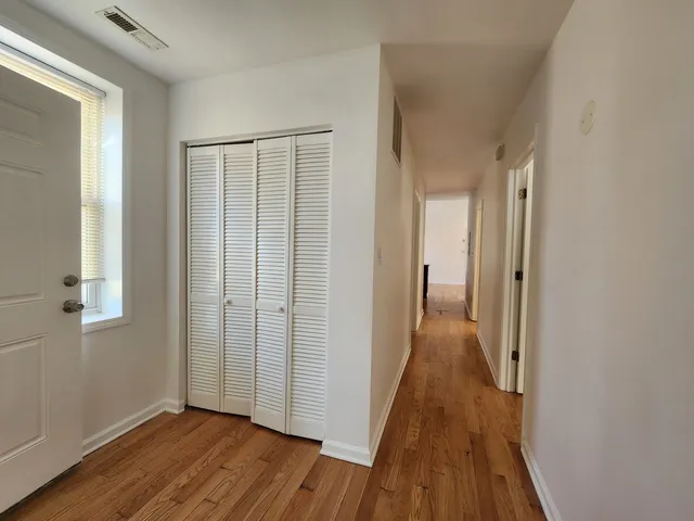 a view of a hallway with wooden floor and staircase
