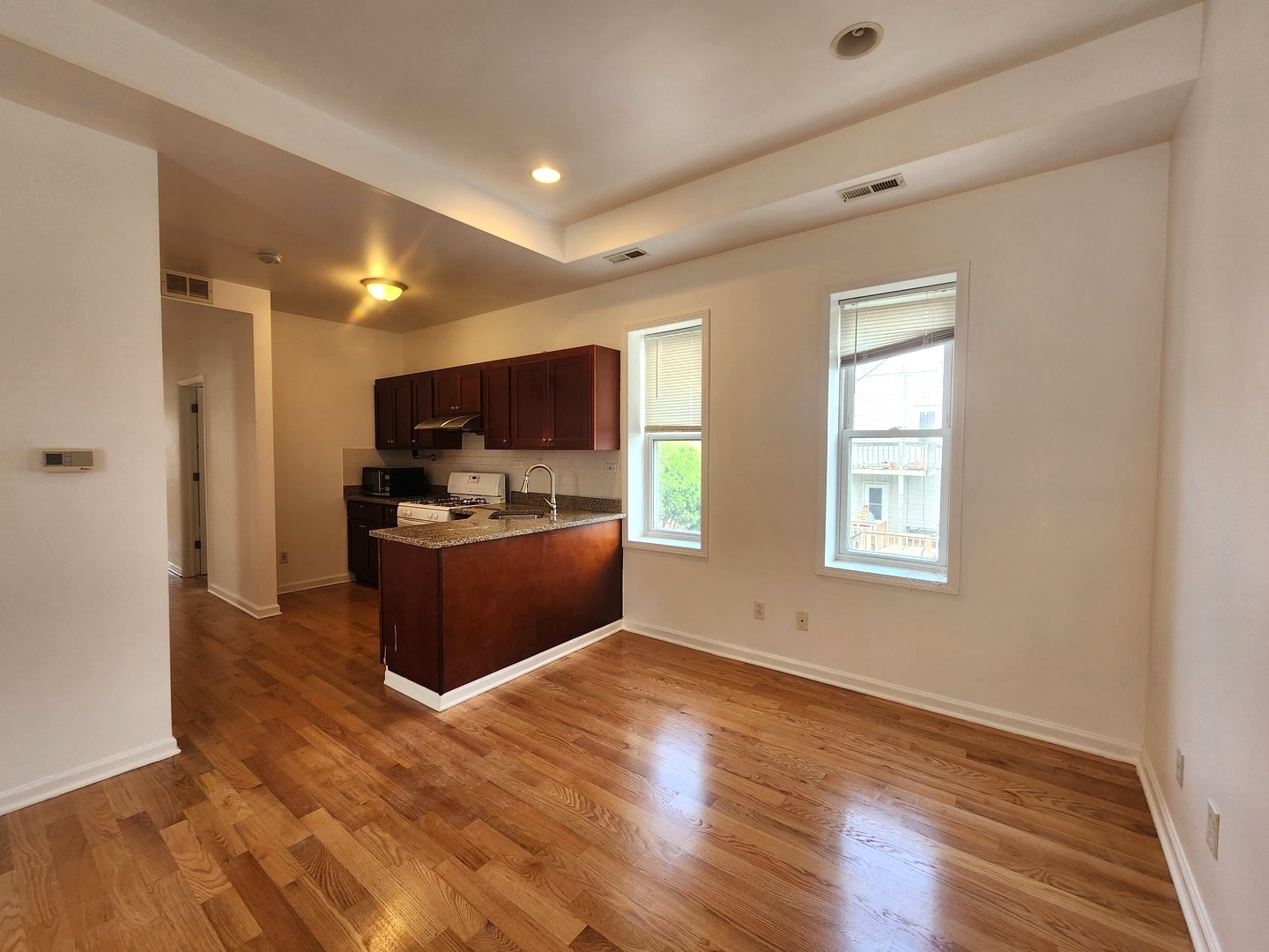 2713 South Crowell Street Chicago, IL 60608 - Photo 25 of 50 a kitchen with stainless steel appliances kitchen island granite countertop a stove top oven a sink dishwasher a refrigerator and a microwave oven with wooden floor