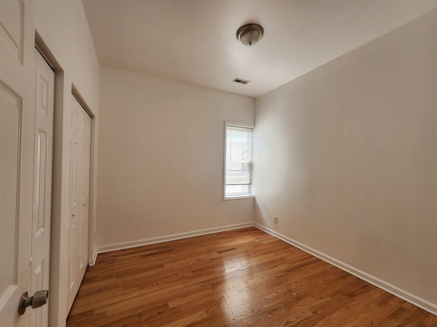 2713 South Crowell Street Chicago, IL 60608 - Photo 37 of 50 an empty room with wooden floor and windows