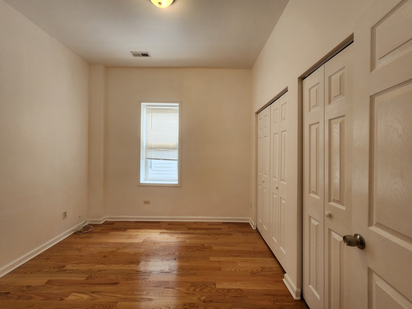 2713 South Crowell Street Chicago, IL 60608 - Photo 40 of 50 a view of an empty room with wooden floor and a window