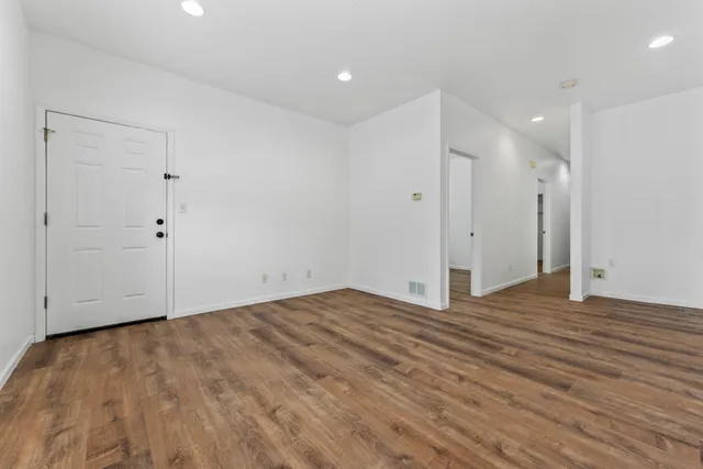 a view of an empty room with wooden floor