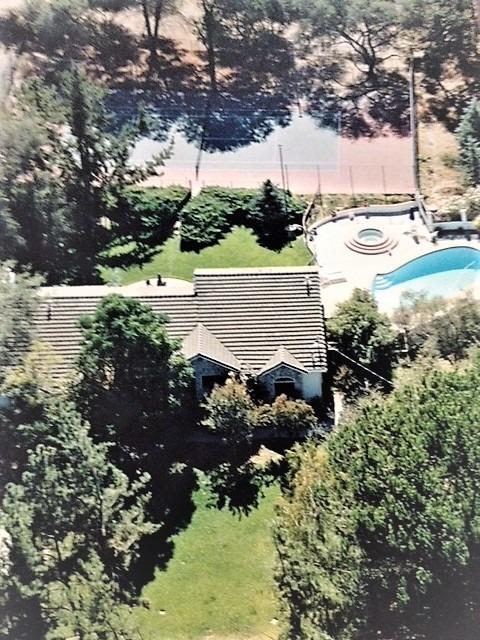 Aerial view of house looking south -- built in pool, spa, patio area, tennis court... separate area on fence line of tennis court could be play area, dog run, garden area etc.