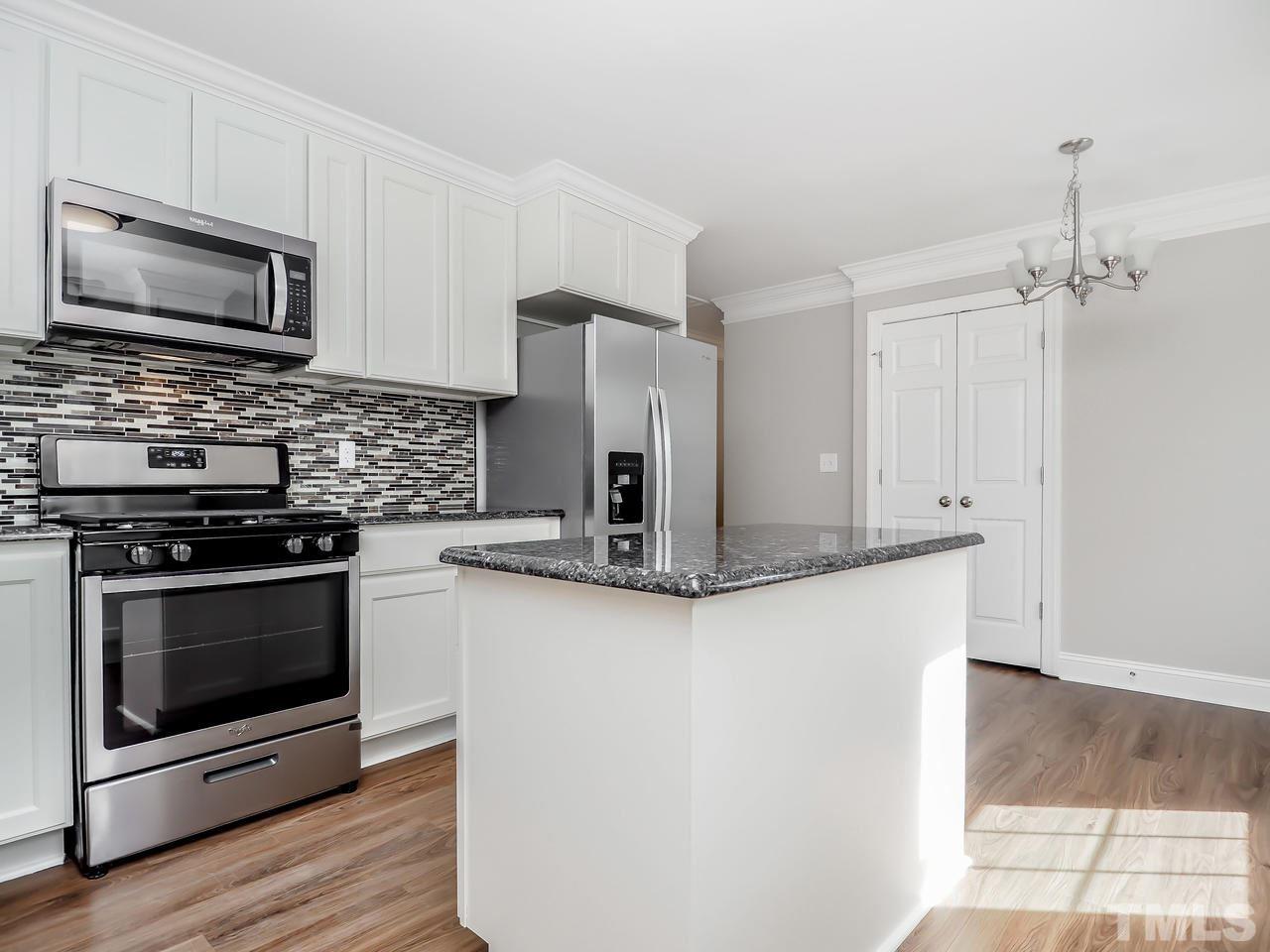 1111 Wyldewood Road Durham, NC 27704 - Photo 8 of 17 a kitchen with stainless steel appliances granite countertop a stove a microwave and a refrigerator