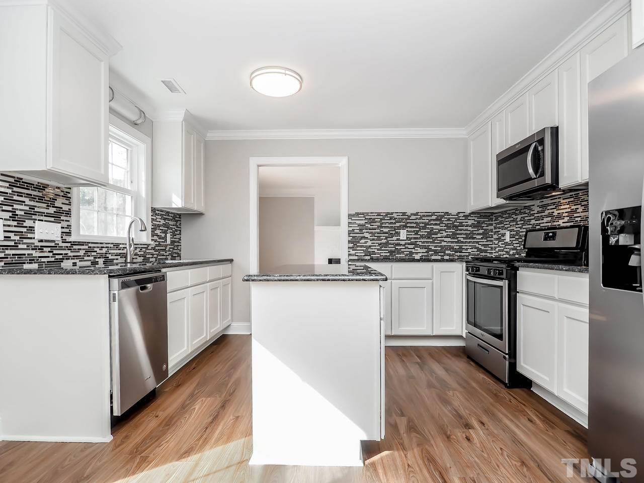 1111 Wyldewood Road Durham, NC 27704 - Photo 9 of 17 a kitchen with white cabinets and appliances