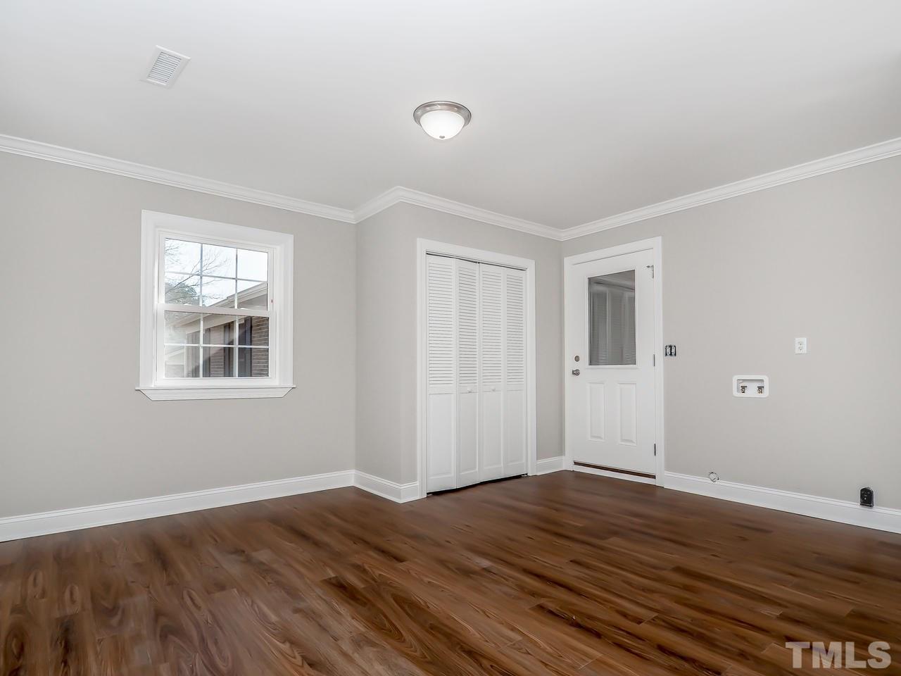 1111 Wyldewood Road Durham, NC 27704 - Photo 10 of 17 a view of an empty room with wooden floor and a window
