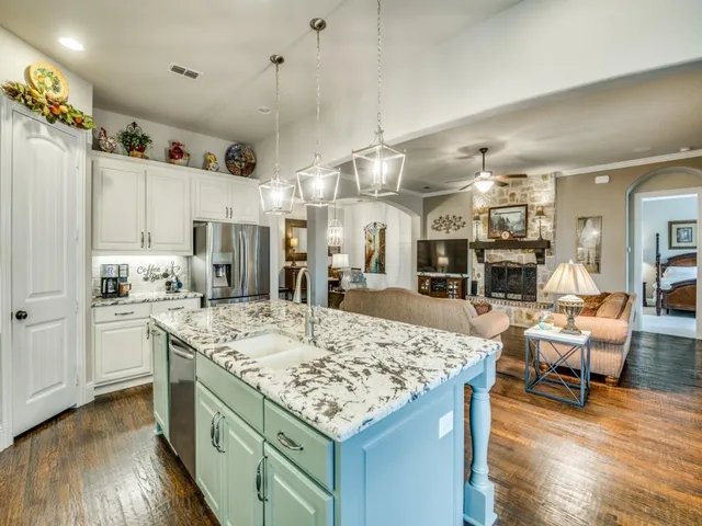 a kitchen with stainless steel appliances granite countertop a stove refrigerator and wooden floor