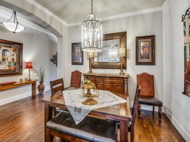 a view of a dining room with furniture a chandelier and wooden floor