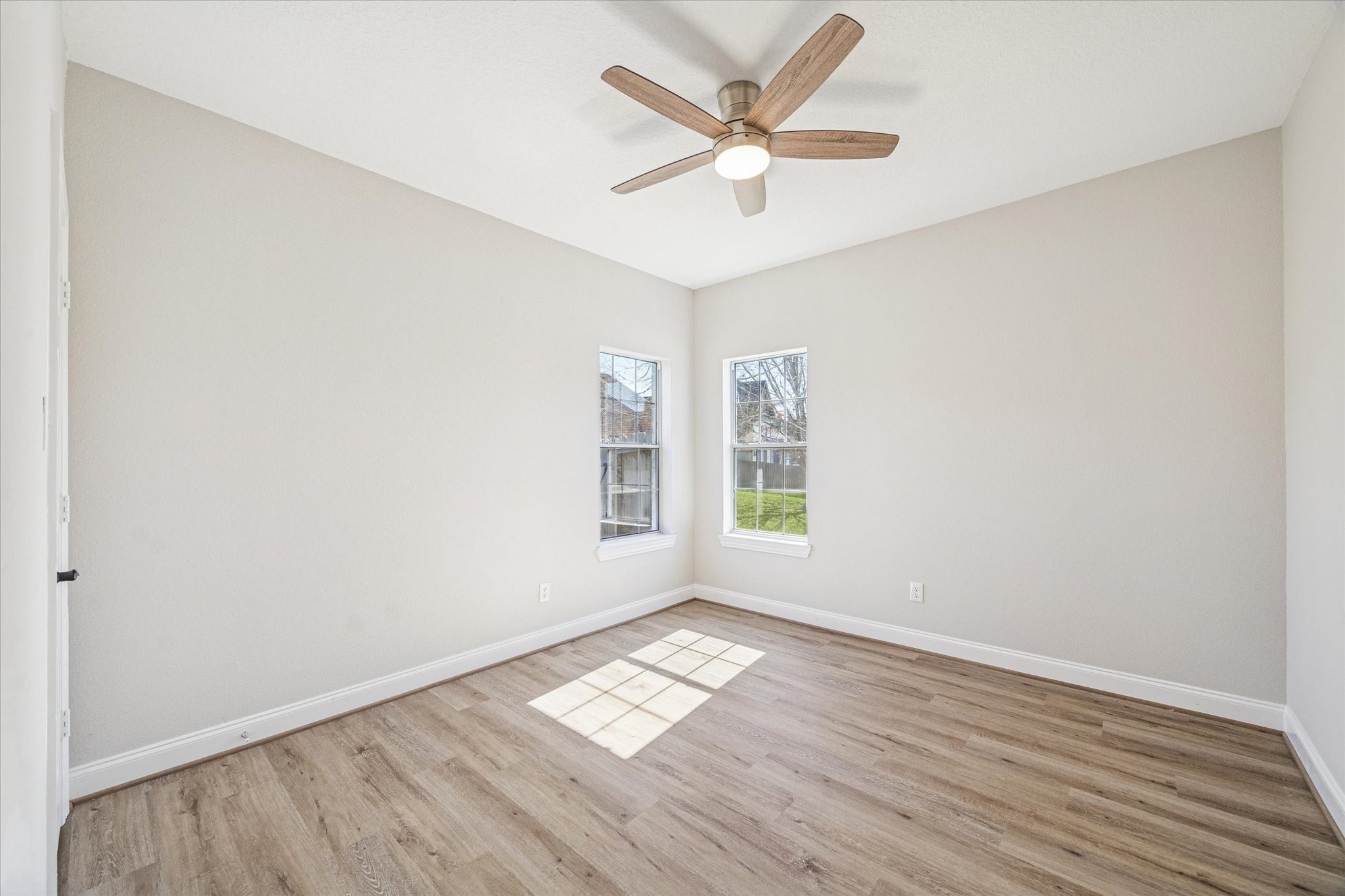 5437 Edgewater Court Willis, TX 77318 - Photo 21 of 29 an empty room with wooden floor and windows