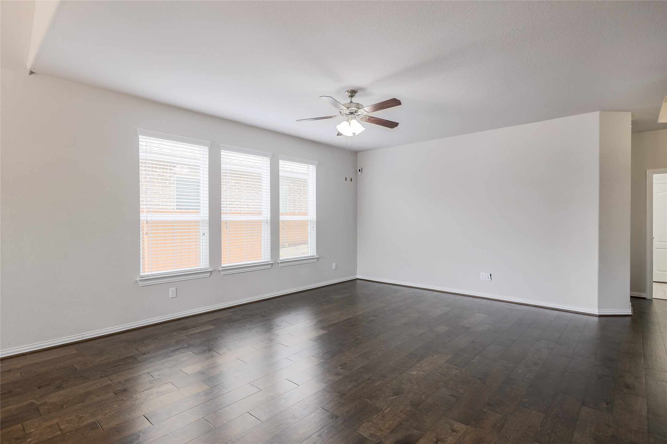 205 Penna Lane Georgetown, TX 78628 - Photo 5 of 32 Rich hardwood flooring stretches across this naturally illuminated living space, offering warmth and style.