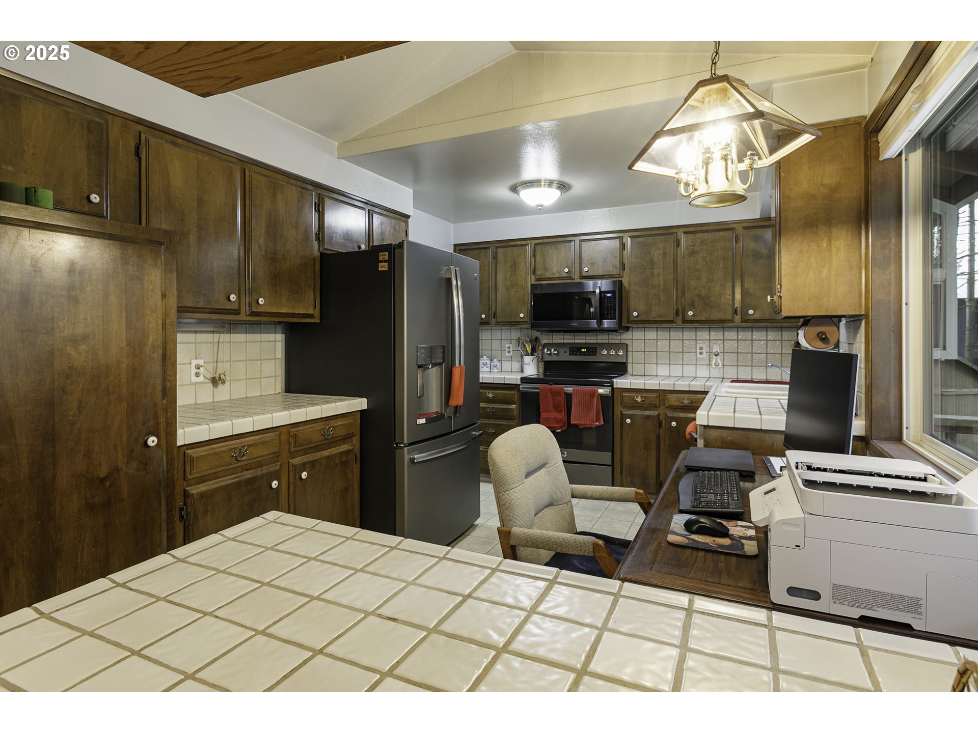 22285 Southeast Ridgeview Drive Damascus, OR 97089 - Photo 12 of 32 a kitchen with stainless steel appliances kitchen island granite countertop a refrigerator and a stove top oven