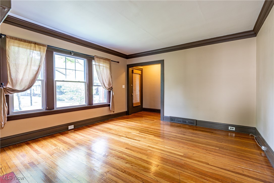 3228 East Fairfax Road Cleveland, OH 44118 - Photo 11 of 49 Empty room with light wood-type flooring and ornamental molding