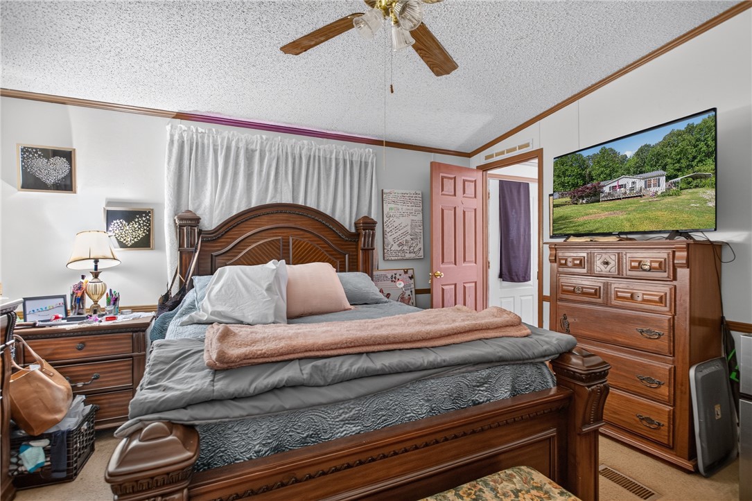 418 Chauga Road Westminster, SC 29693 - Photo 13 of 38 A traditional wooden bed frame anchors this welcoming bedroom, creating a peaceful personal retreat.