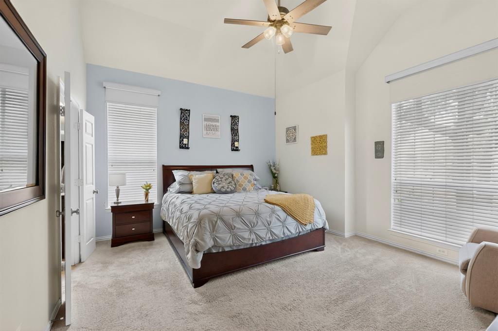 4004 White Porch Road Plano, TX 75024 - Photo 20 of 40 a bedroom with a bed and a chandelier