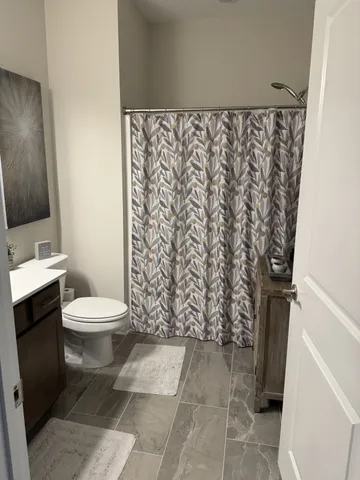 a bathroom with a toilet and a shower