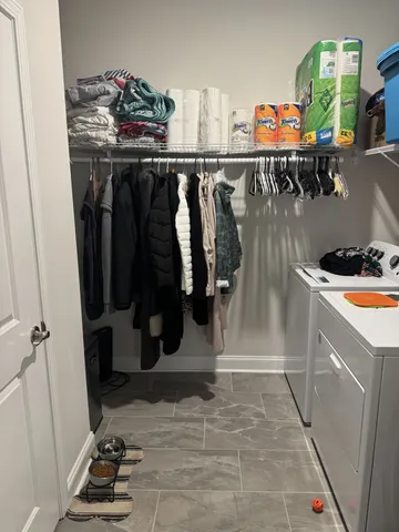 a view of walk in closet with clothes and shoes