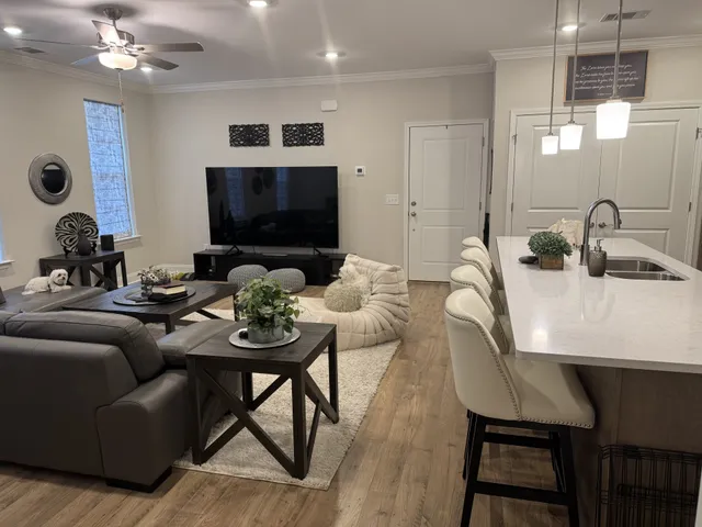 a living room with furniture a flat screen tv and kitchen view