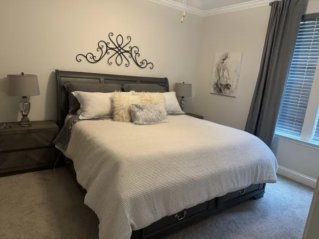 a large bed sitting in a bedroom next to a window