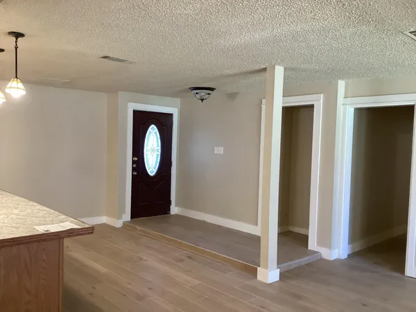 a view of a room with wooden floor and white wall