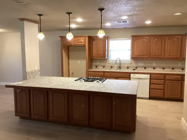 a kitchen with kitchen island a sink stainless steel appliances and cabinets