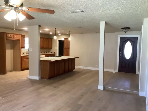 a view of a kitchen and a chandelier fan wooden floor and a kitchen