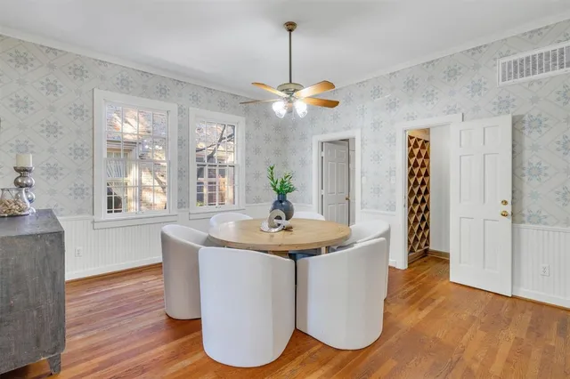 a dining room with wooden floor a chandelier a wooden table and chairs