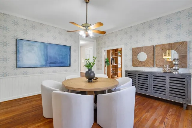 a dining room with wooden floor a chandelier a glass table and chairs