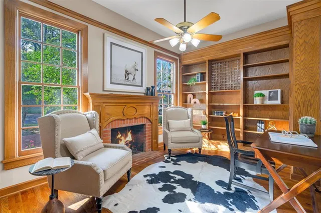 a living room with furniture a fireplace and a large window