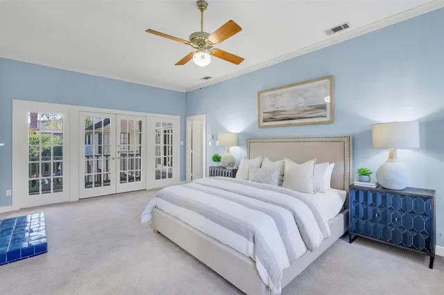 a spacious bedroom with a large bed and a chandelier