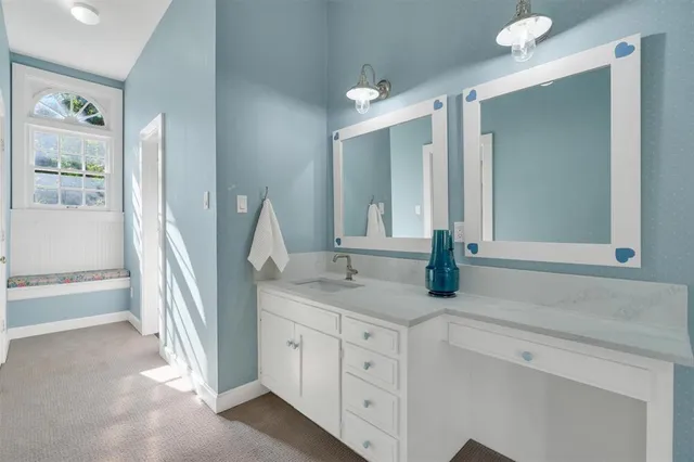 a bathroom with a granite countertop sink and a mirror