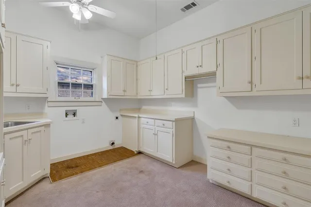 a kitchen with white cabinets and sink