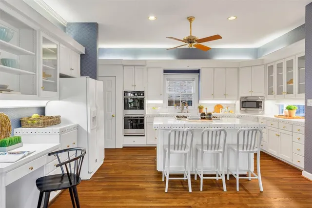 a kitchen with stainless steel appliances kitchen island granite countertop a table chairs and a refrigerator