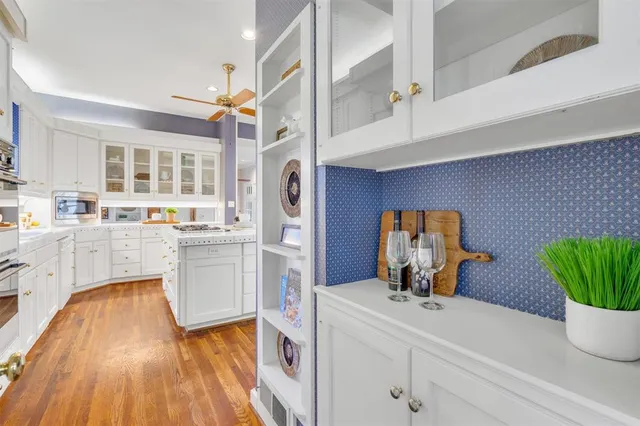 a living room with stainless steel appliances furniture and a kitchen view