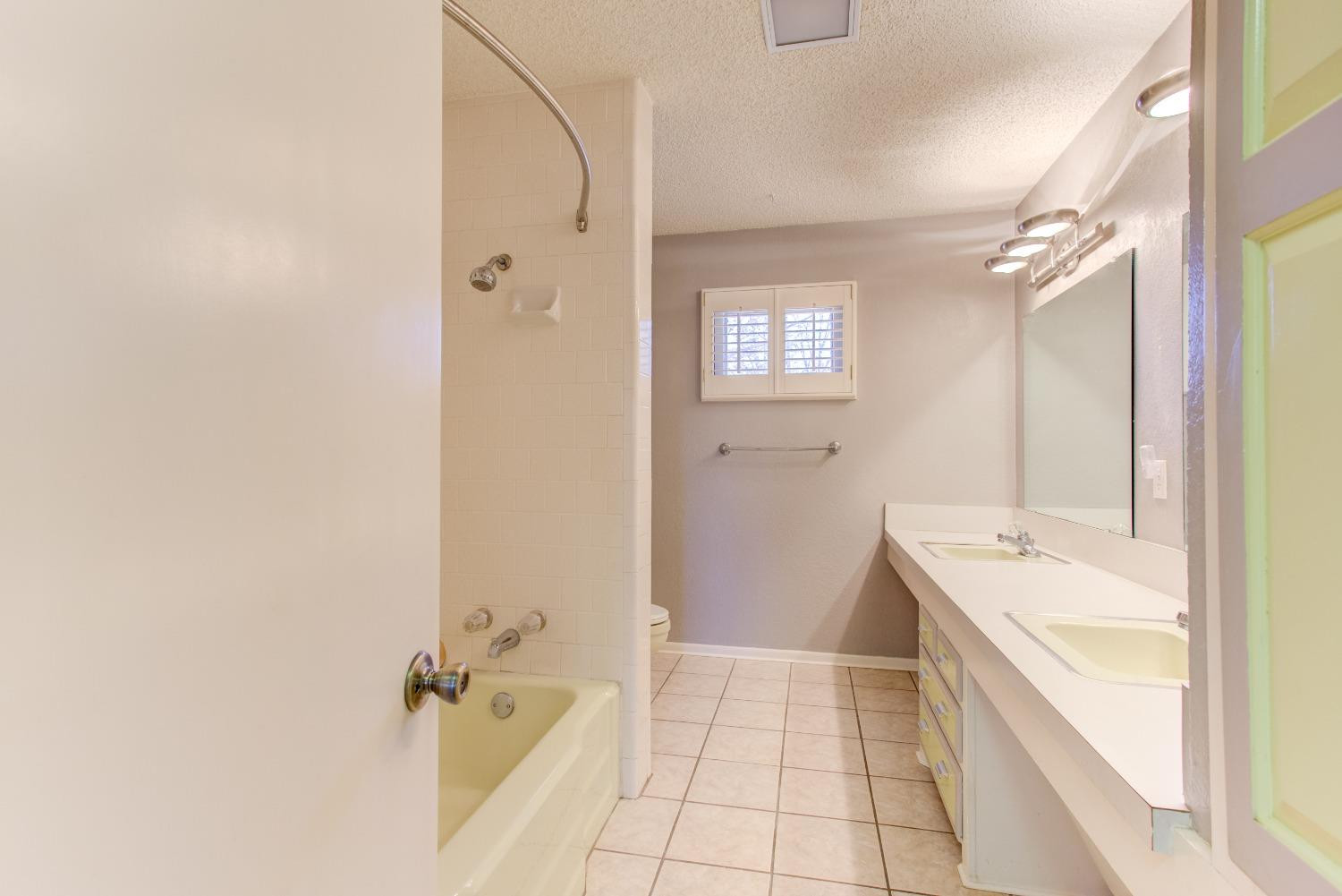 3410 40th Street Lubbock, TX 79413 - Photo 15 of 33 a bathroom with a sink a mirror and a bathtub