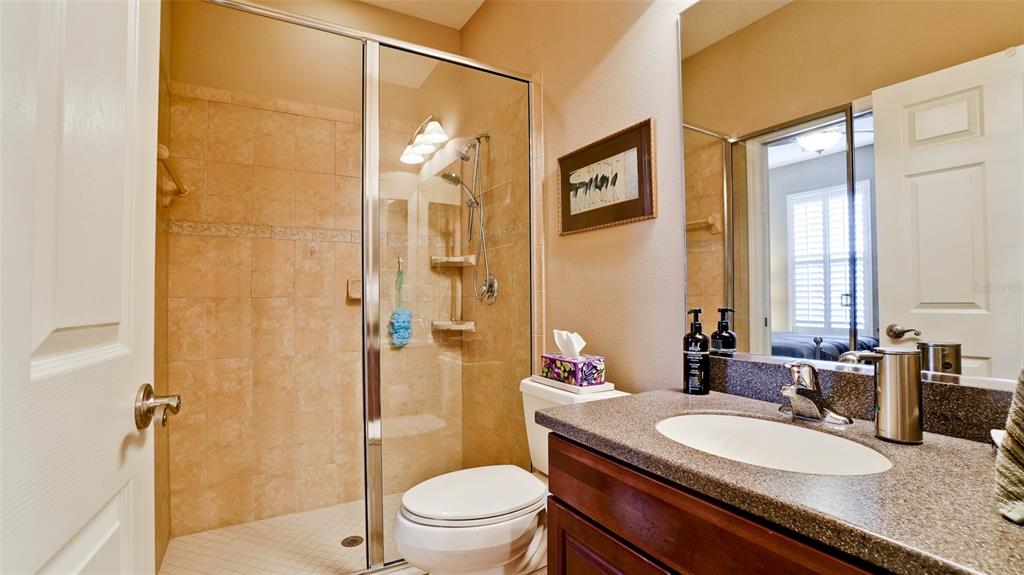 7401 Hamilton Road Bradenton, FL 34209 - Photo 20 of 35 a bathroom with a granite countertop sink toilet a mirror a vanity and shower
