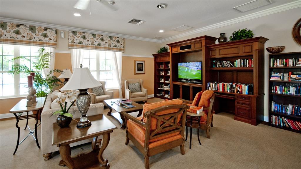 7401 Hamilton Road Bradenton, FL 34209 - Photo 34 of 35 a living room with furniture a bookshelf and a flat screen tv