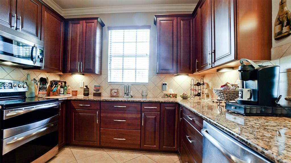 7401 Hamilton Road Bradenton, FL 34209 - Photo 10 of 35 a kitchen with stainless steel appliances granite countertop wooden cabinets and a stove top oven