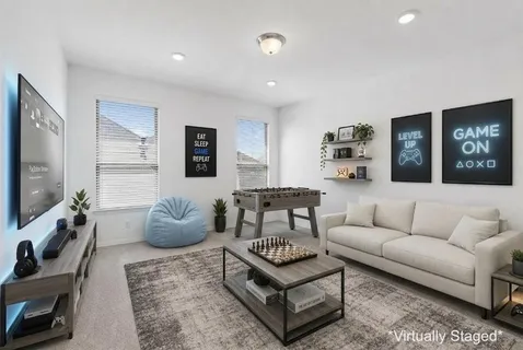 a living room with furniture a flat screen tv and kitchen view