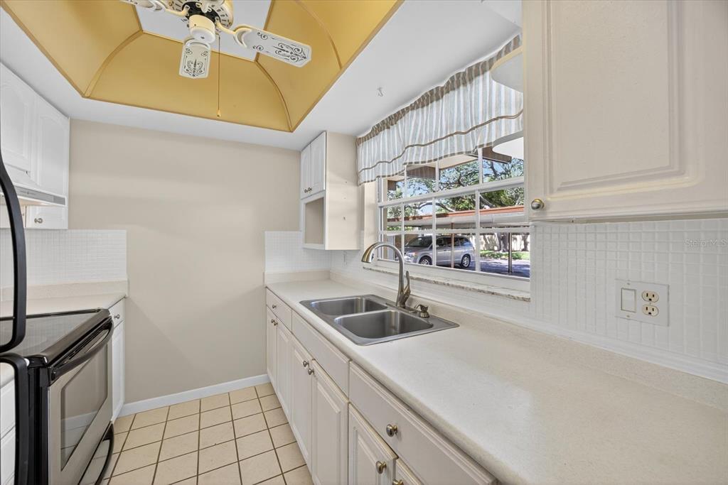 1701 Pinehurst Road, Unit 36C Dunedin, FL 34698 - Photo 16 of 25 a kitchen with a sink a stove and cabinets