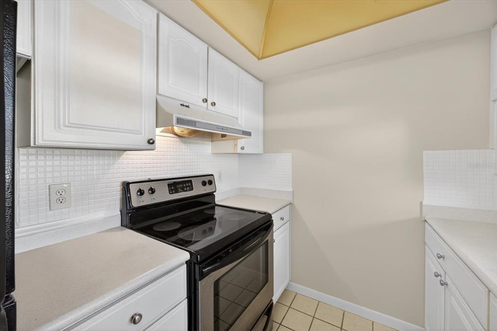 1701 Pinehurst Road, Unit 36C Dunedin, FL 34698 - Photo 6 of 25 a kitchen with white cabinets and appliances