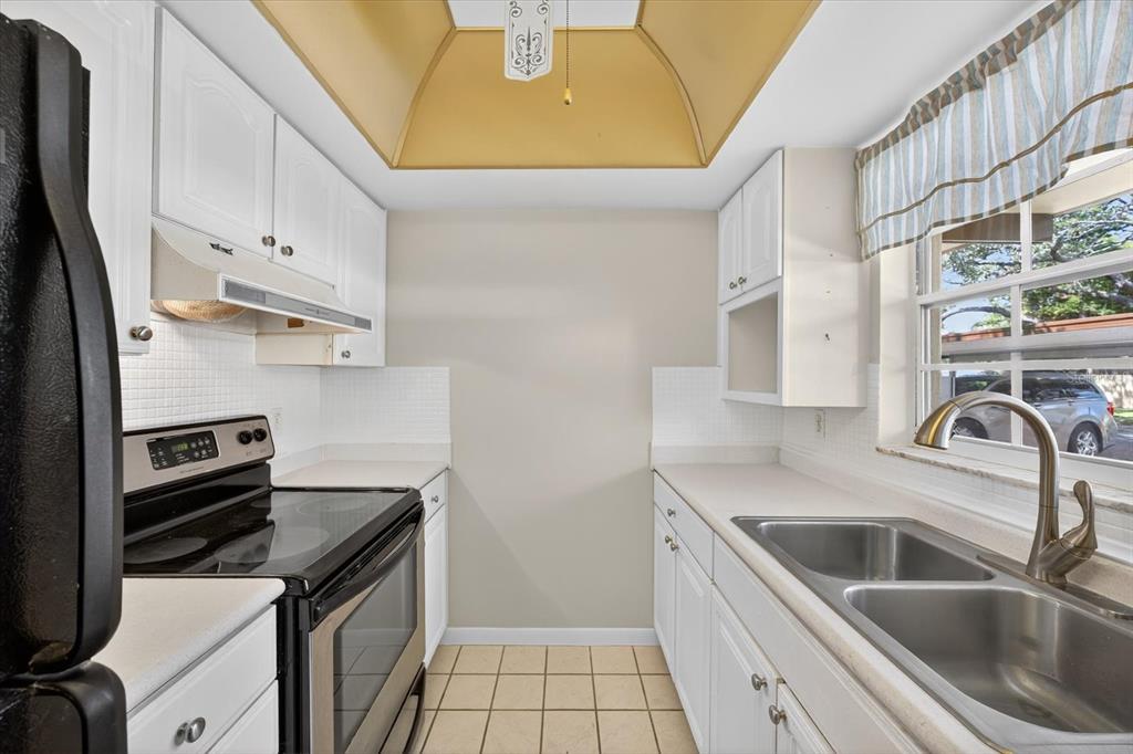 1701 Pinehurst Road, Unit 36C Dunedin, FL 34698 - Photo 7 of 25 a kitchen with stainless steel appliances a sink a stove and a refrigerator with wooden floor