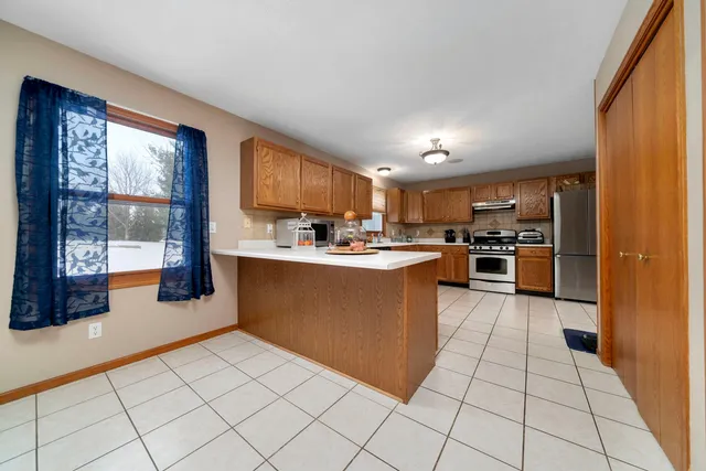 a kitchen with stainless steel appliances granite countertop a refrigerator and a stove top oven