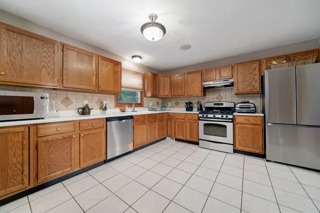 a kitchen with stainless steel appliances granite countertop a stove sink and cabinets