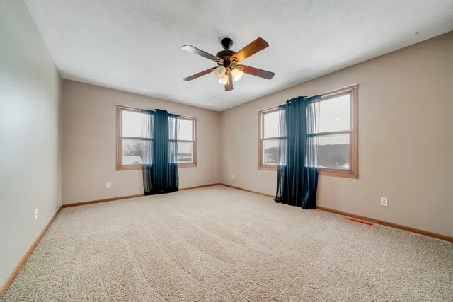 an empty room with windows and closet